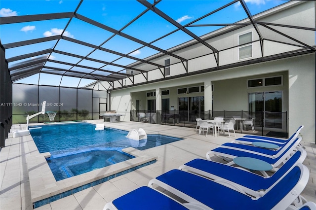 view of pool featuring glass enclosure, an in ground hot tub, and a patio area