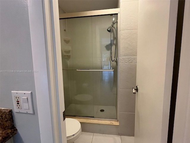 bathroom featuring tile patterned flooring, an enclosed shower, and toilet