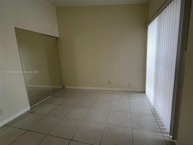 unfurnished bedroom featuring a closet and light tile patterned floors