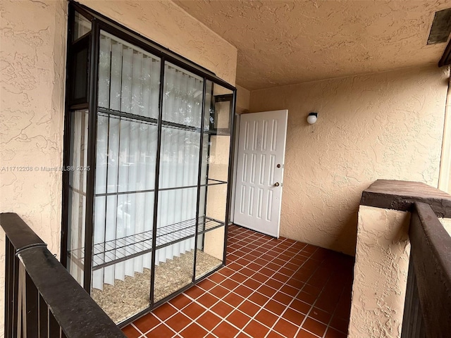 view of exterior entry with a balcony