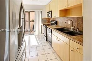 kitchen featuring sink, light tile patterned floors, a healthy amount of sunlight, and appliances with stainless steel finishes