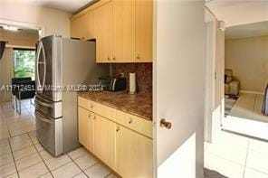 kitchen featuring stainless steel refrigerator, light brown cabinets, and light tile patterned flooring