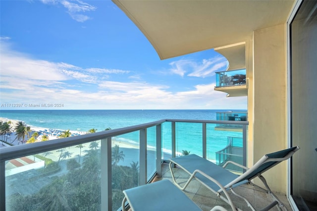 balcony featuring a water view and a view of the beach