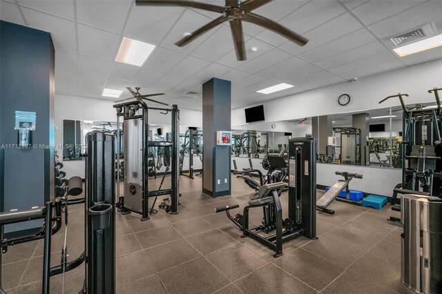 workout area featuring ceiling fan and a drop ceiling