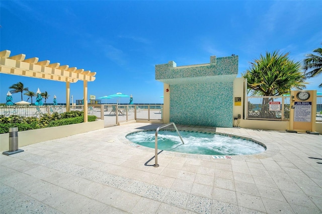 view of swimming pool with a water view and a hot tub