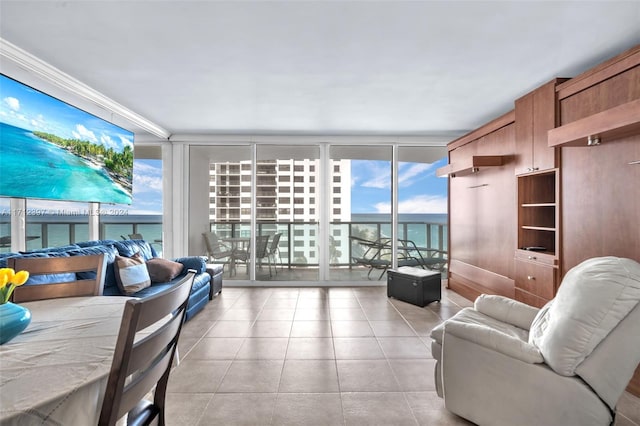 living room with a wealth of natural light, a water view, and a wall of windows