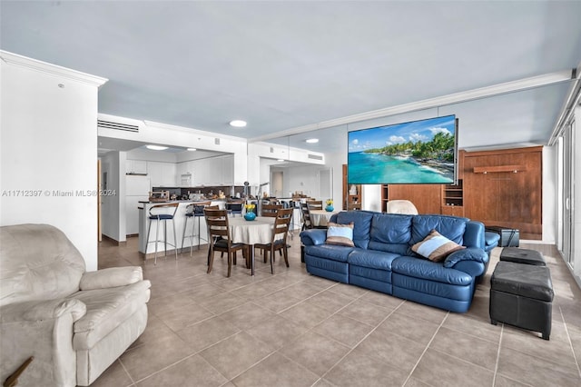 living room with crown molding and light tile patterned floors