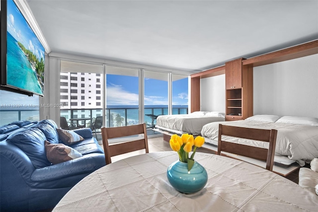 bedroom featuring access to outside, floor to ceiling windows, and a water view