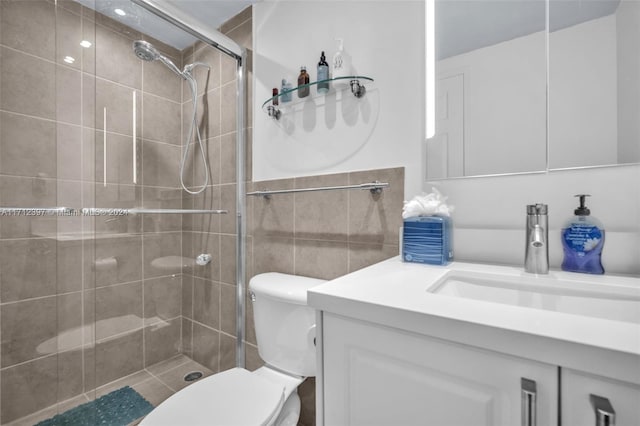 bathroom with vanity, toilet, and a shower with shower door