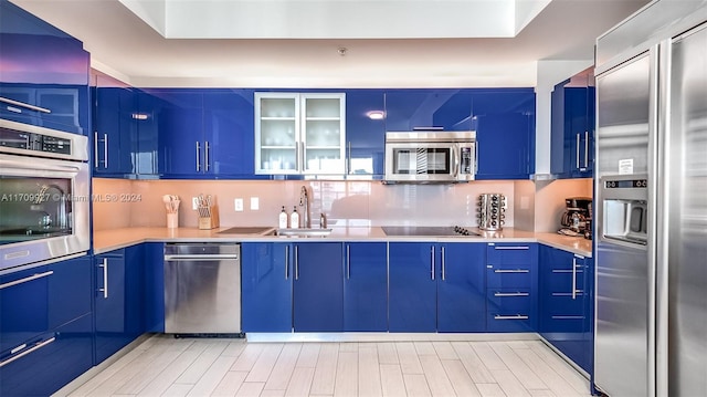 kitchen with blue cabinets, sink, appliances with stainless steel finishes, and tasteful backsplash