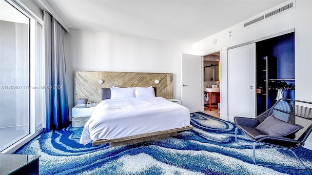 bedroom featuring ensuite bath, a closet, and dark carpet