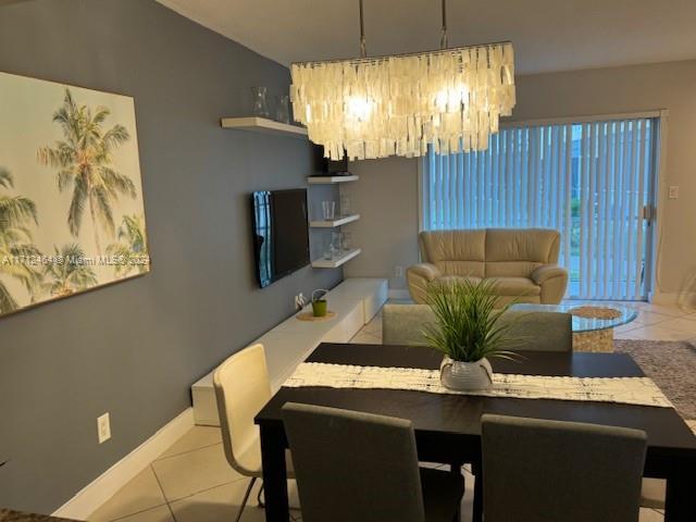 dining space featuring light tile patterned floors and an inviting chandelier