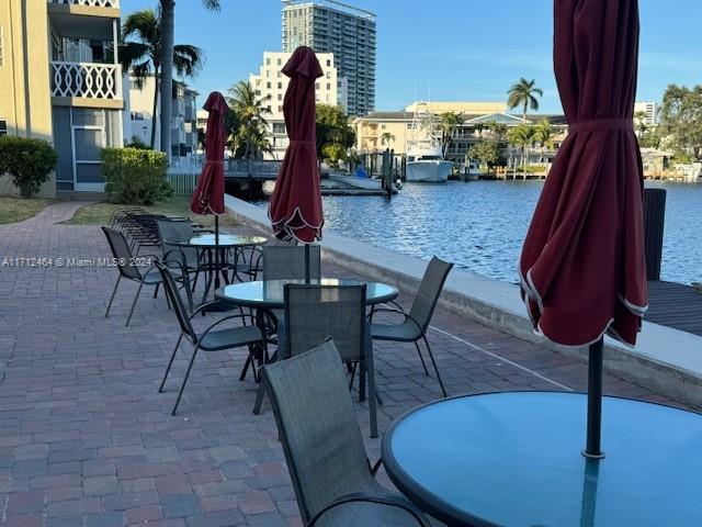 450 Golden Isles Dr Unit 1C, Hallandale Beach, FL 33009 - view of patio / terrace featuring a water view and outdoor dining space