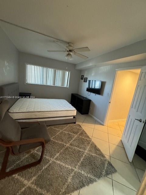 bedroom with ceiling fan and light tile patterned floors