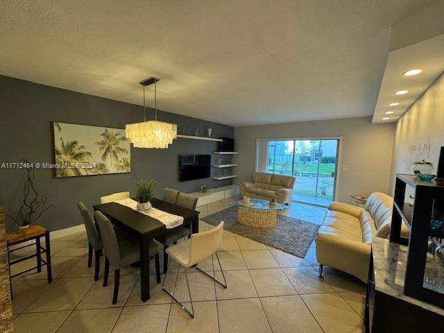 tiled dining area featuring a notable chandelier