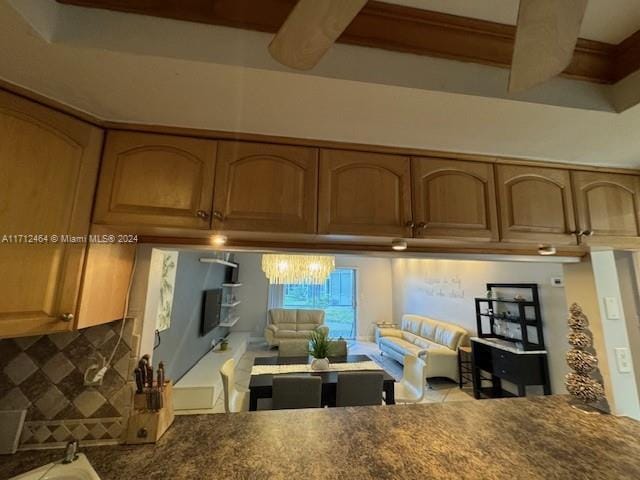 450 Golden Isles Dr Unit 1C, Hallandale Beach, FL 33009 - kitchen with beam ceiling, decorative backsplash, and dark countertops