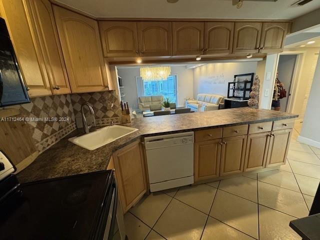 kitchen with kitchen peninsula, dishwasher, light tile patterned floors, and sink