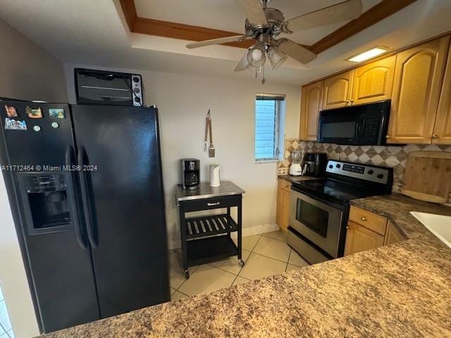 kitchen featuring decorative backsplash, a tray ceiling, ceiling fan, black appliances, and light tile patterned floors