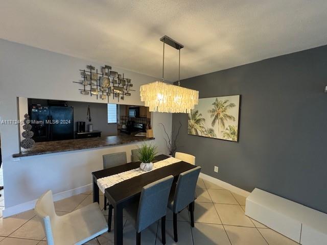 dining space featuring light tile patterned floors and a notable chandelier