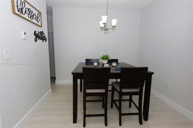 dining area featuring a notable chandelier and light wood-type flooring