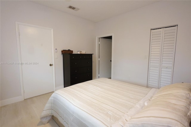 bedroom with light wood-type flooring and a closet