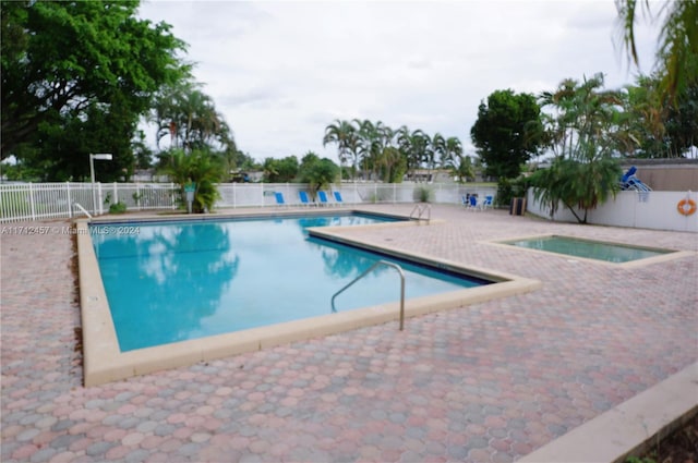 view of pool featuring a patio area and a hot tub