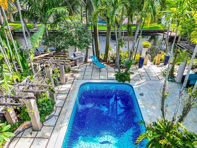 view of swimming pool with a patio area and a water view