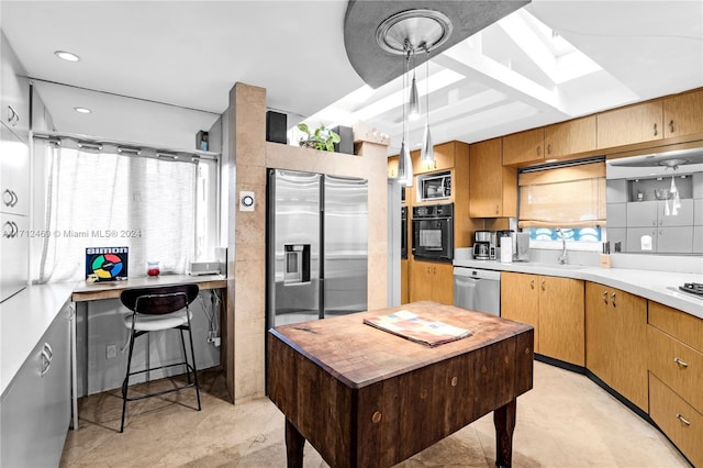 kitchen featuring decorative light fixtures, sink, and appliances with stainless steel finishes