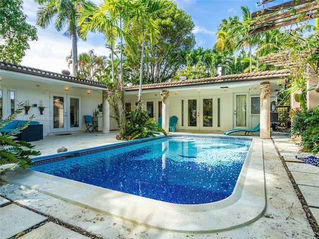 view of pool with french doors and a patio area