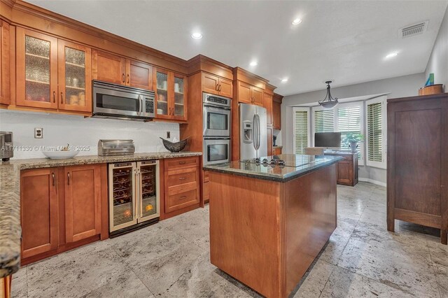 kitchen with ceiling fan, wine cooler, kitchen peninsula, decorative light fixtures, and appliances with stainless steel finishes