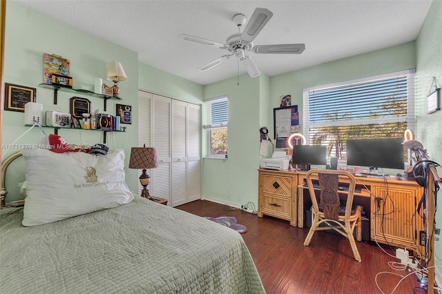 bedroom with dark hardwood / wood-style floors, a textured ceiling, ceiling fan, and a closet