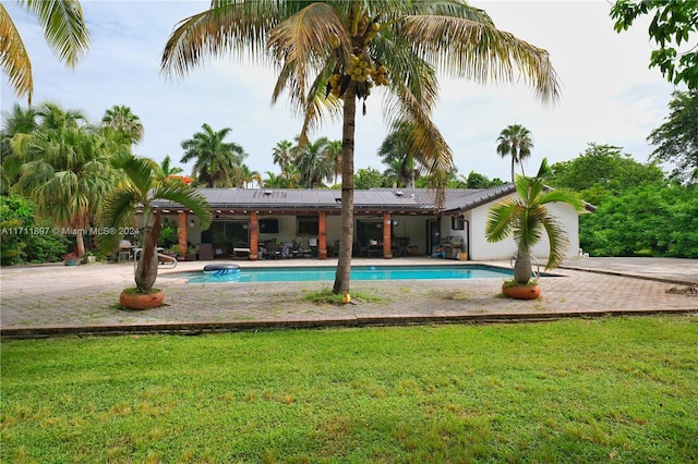 view of pool with a patio area and a lawn