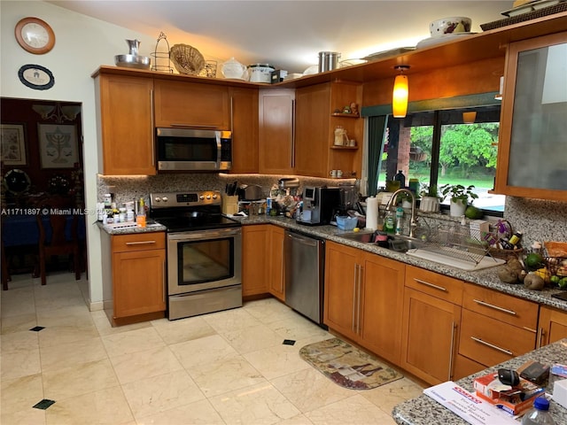 kitchen with backsplash, stone counters, sink, and stainless steel appliances