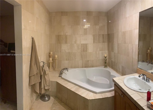 bathroom with vanity, tile patterned floors, tile walls, and tiled tub