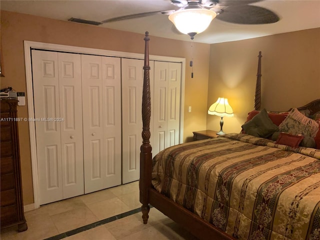 bedroom featuring multiple closets, ceiling fan, and light tile patterned floors