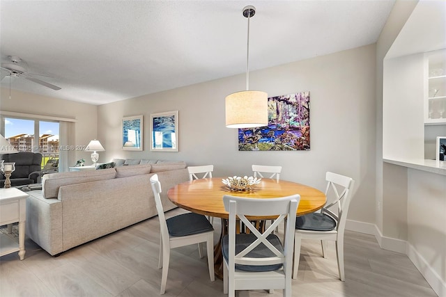 dining space featuring a textured ceiling, light hardwood / wood-style flooring, and ceiling fan