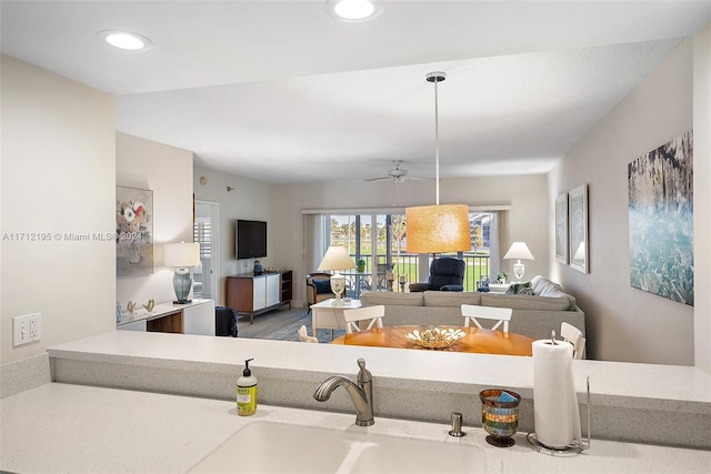 living room featuring hardwood / wood-style floors, ceiling fan, and sink