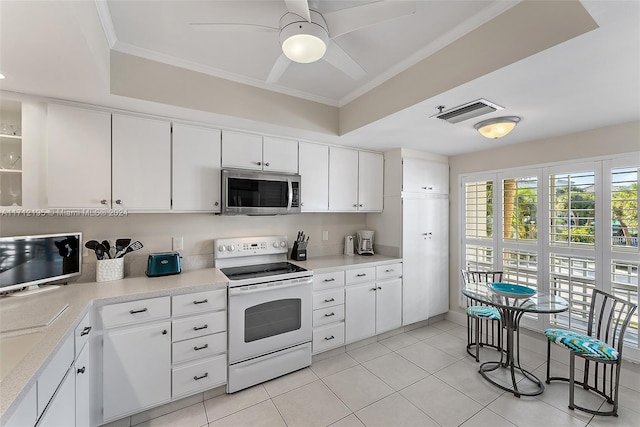 kitchen with white electric range oven, light tile patterned flooring, and white cabinetry