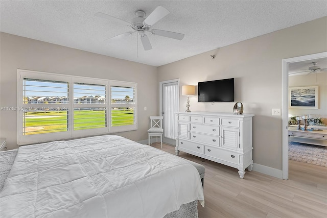 bedroom with ceiling fan, a textured ceiling, and light wood-type flooring