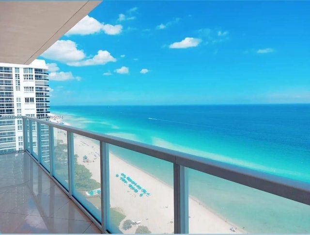 balcony featuring a water view and a view of the beach