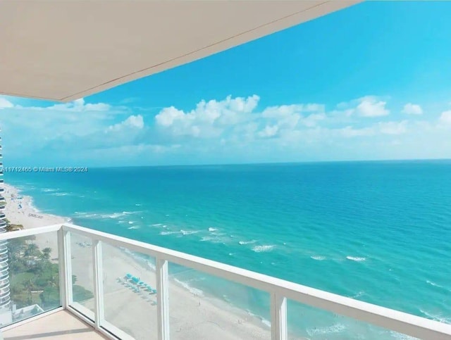 balcony featuring a water view and a beach view