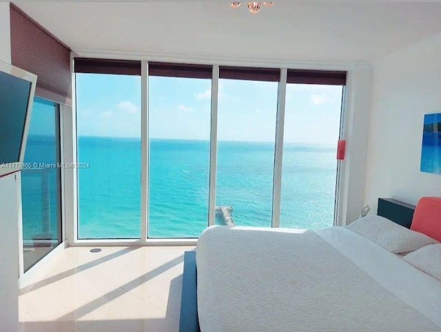 bedroom with a water view and a wall of windows