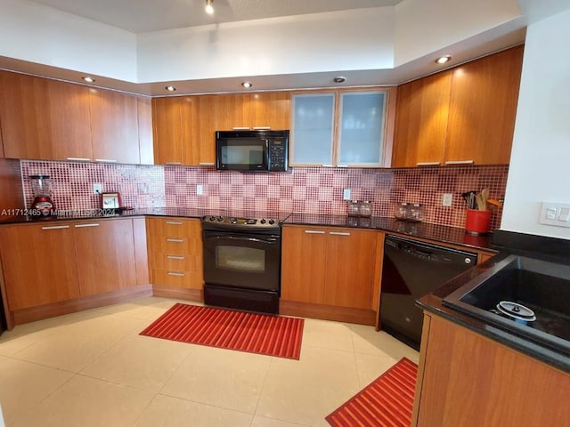 kitchen featuring decorative backsplash, light tile patterned floors, and black appliances