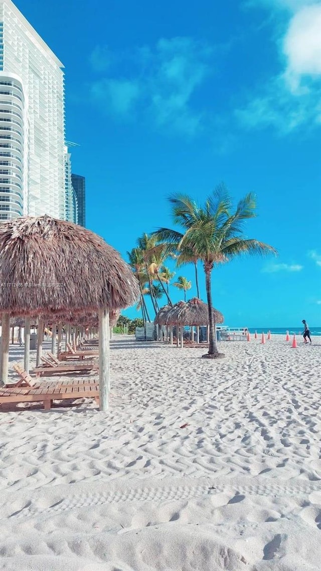 view of home's community with a gazebo, a water view, and a beach view