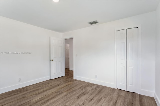 unfurnished bedroom with wood-type flooring and a closet