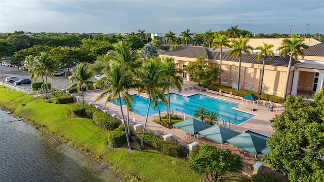 view of pool featuring a patio area and a water view