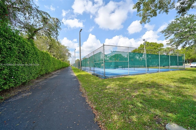 view of sport court with a yard