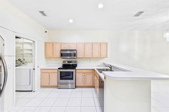 kitchen with light brown cabinetry, sink, stainless steel appliances, and washing machine and clothes dryer