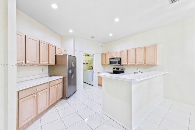 kitchen featuring kitchen peninsula, light brown cabinetry, stainless steel appliances, and washer / dryer