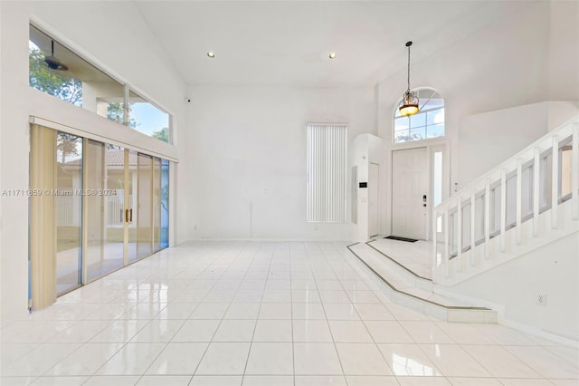 foyer with a towering ceiling and light tile patterned floors